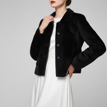 Įkelti nuotrauką į galerijos peržiūros programą, A woman models a short black velvet jacket over a white dress against a light gray studio background.
