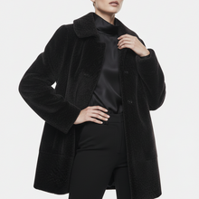 Įkelti nuotrauką į galerijos peržiūros programą, A model wearing a black textured teddy coat over a black satin top and black pants, photographed against a clean light gray studio background.
