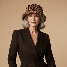 Load image into Gallery viewer, Woman wearing a leopard print hat and dark brown suit against a beige background
