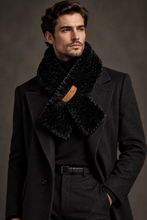 Įkelti nuotrauką į galerijos peržiūros programą, A man wearing a dark charcoal wool coat, black turtleneck, and a thick black faux-fur scarf with a small tan leather brand tab, posed against a dark brown studio background.
