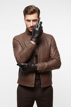 Įkelti nuotrauką į galerijos peržiūros programą, A man wearing a brown leather jacket and black leather gloves, posing against a light gray studio background.
