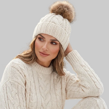Įkelti nuotrauką į galerijos peržiūros programą, Stylish woman wearing Vilniaus Kailiai Mod. PAULINA hat, a chic fashion accessory with a classic design and warm material.
