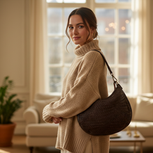 Load image into Gallery viewer, Woman in a beige sweater holding a brown handbag in a living room.
