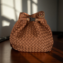 Load image into Gallery viewer, Brown woven handbag on a wooden surface with a blurred background

