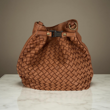 Load image into Gallery viewer, Brown woven handbag on a light wooden surface with a neutral background
