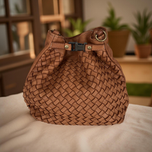 Load image into Gallery viewer, Brown woven handbag on a white surface with a blurred indoor background
