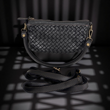 Load image into Gallery viewer, Black woven handbag with a strap on a dark background
