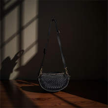 Load image into Gallery viewer, Black woven handbag on a wooden surface with a dark background

