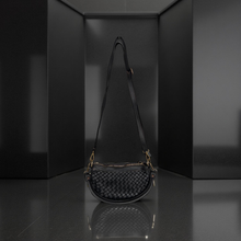 Load image into Gallery viewer, Black woven handbag on a reflective surface with a dark background
