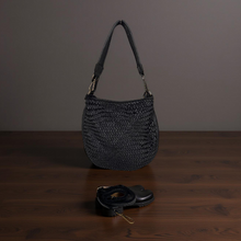 Load image into Gallery viewer, Black woven handbag on a wooden surface with a dark background

