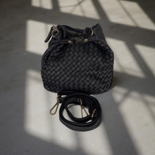 Load image into Gallery viewer, Black woven handbag with a strap on a light gray surface
