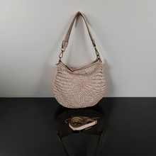 Load image into Gallery viewer, Beige woven handbag on a reflective black surface with a light gray background
