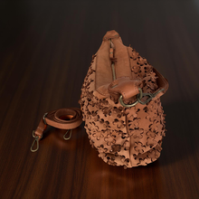 Load image into Gallery viewer, Brown leather bag with intricate cut-out design on a dark surface
