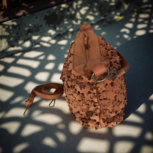 Load image into Gallery viewer, Brown leather handbag with intricate patterns on a textured surface

