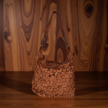 Load image into Gallery viewer, Floral-patterned handbag on a wooden surface with a wooden background
