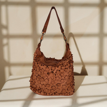 Load image into Gallery viewer, Brown leather handbag with floral patterns on a white surface with shadow effect
