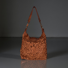 Load image into Gallery viewer, Brown leather handbag with floral patterns on a gray background

