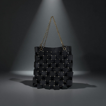 Load image into Gallery viewer, Black woven handbag with chain handle on a dark background
