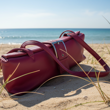 Load image into Gallery viewer, Red handbag on a sandy beach with ocean in the background
