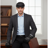 Man in a suit with a cap and gloves sitting in an office setting