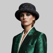 Load image into Gallery viewer, A model wearing a dark gray textured bucket hat and a green brocade blazer with a white collar, set against a solid light gray background.
