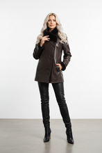 Įkelti nuotrauką į galerijos peržiūros programą, A woman modeling a dark brown faux-leather coat with a black faux-fur collar, paired with black leather pants and boots, standing against a plain white studio background.
