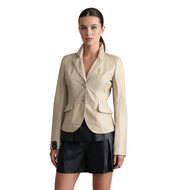 Woman wearing a beige blazer over a black outfit on a white background