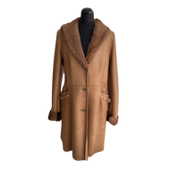 A camel brown Nappa sheepskin midi-length coat with a shawl collar, buttons down the front, and fur lining at the hood.