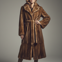 Įkelti nuotrauką į galerijos peržiūros programą, A model wearing a luxurious brown fur coat with a matching belt and brown leather boots, standing against a neutral gray studio background.
