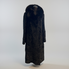 Įkelti nuotrauką į galerijos peržiūros programą, A long black fur coat with a large plush fur collar, displayed on a mannequin against a light gray studio background.
