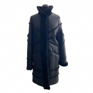 A black sheepskin fur coat with sheep wool trimming in front, press studs and hidden pockets.