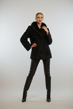 Load image into Gallery viewer, A model stands against a light gray studio background wearing a black textured jacket with a dark fur collar, black leather-look pants, and black knee-high boots.
