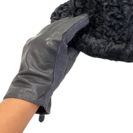 A close-up image of a woman's hand wearing a black Nappa leather glove, with the focus on the glove's texture and fit.