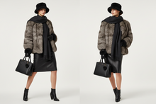 Įkelti nuotrauką į galerijos peržiūros programą, A side-by-side comparison of a model wearing a winter outfit. The outfit includes a brown and black faux fur coat, a black scarf, a black leather skirt, black boots, a black bucket hat, and a black handbag, set against a plain light gray studio background.
