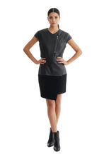 Load image into Gallery viewer, A model stands against a white studio background wearing a short-sleeve black dress with a front zipper detail and black ankle boots.

