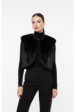 Įkelti nuotrauką į galerijos peržiūros programą, A model wearing a black faux fur cropped vest over a black turtleneck and black trousers, shot against a solid light gray background.
