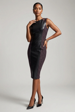 Load image into Gallery viewer, A woman models a sleeveless bodycon dress with black faux-leather panels and textured dark purple side panels, paired with black high heels, against a light gray studio background.
