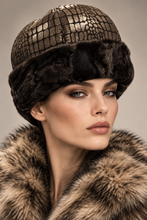 Įkelti nuotrauką į galerijos peržiūros programą, A close-up portrait of a model wearing a metallic gold crocodile-embossed hat with a dark brown fur brim and a matching fur collar, against a neutral beige background.
