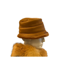 A cinnamon brown sheepskin fur cap displayed on a mannequin head, featuring a soft fur design with no lining and a fur inner.
