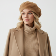 Woman wearing a beige beret, sweater, and coat on a white background