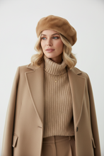 Įkelti nuotrauką į galerijos peržiūros programą, Woman wearing a beige beret, sweater, and coat against a white background
