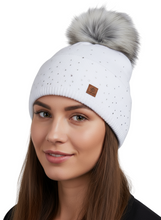 Load image into Gallery viewer, White beanie with a fur pom-pom worn by a model on a white background
