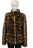 A brown mink jacket with a stand collar, front pockets, and fur hook fastening on a mannequin.