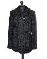Black astrakhan fur jacket bellow hip length, pockets at sides.
