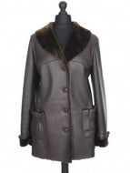 A dark brown Nappa sheepskin fur long jacket with a fur lining, featuring a regular collar, front pockets, and button fastening.