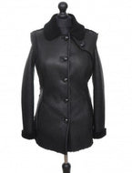 Black long Nappa Merino sheepskin fur fitted jacket with buttons opening, regular collar, and pockets at the front displayed on a mannequin.