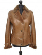 A brown sheepskin fur jacket with Nappa golden effect on the buttons, displayed on a mannequin.