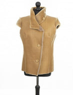 A camel color fitted silhouette short sheepskin vest on a mannequin, with crocodile pattern imitation and button opening front.