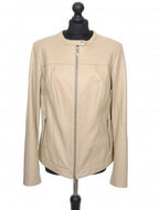Beige short sheep leather jacket with zipper opening and round collar, displayed on a mannequin.