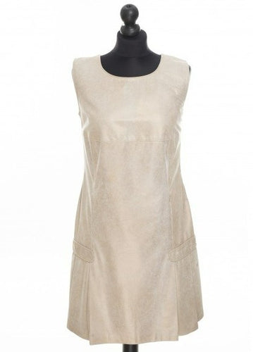 A beige color midi length dress with a golden surface effect, sleeveless with a round neckline and an invisible zipper on the side, displayed on a mannequin.
